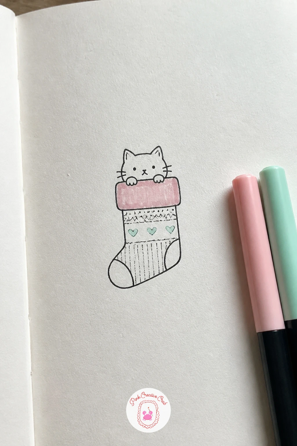 Cat in a Stocking — Cat in a Stocking borrows the same peeking pose but swaps the box for a long stocking shape. Christmas drawing ideas easy doodles