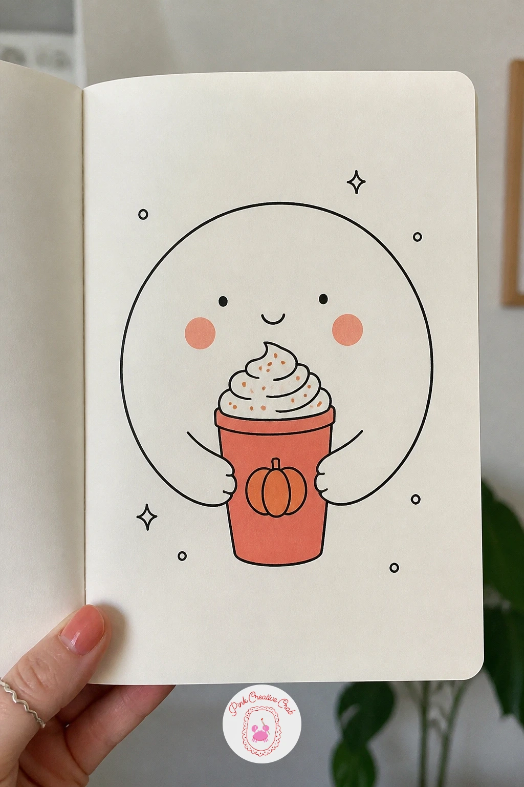 Face With A Pumpkin Spice Latte — Close the set with a cozy face holding up a pumpkin spice latte in a tall cup topped with whipped cream and a sprinkle of