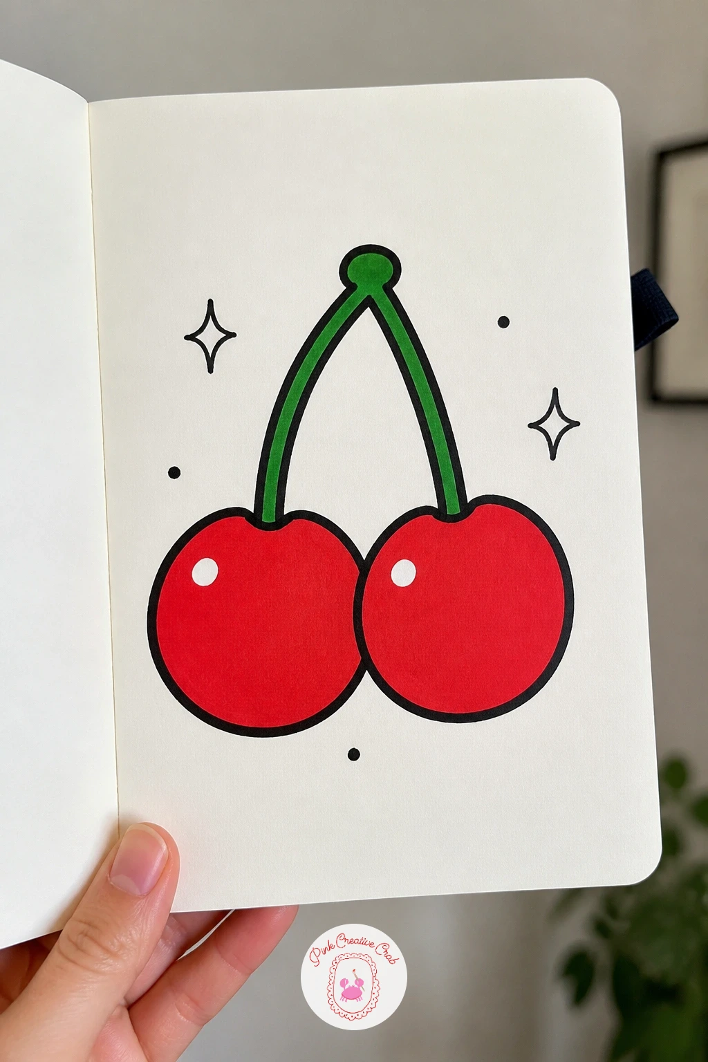 Cherry Pair With a Shine — Move from the sun to something smaller and sweeter: a pair of cherries joined at the stem, each with a little white shine dot. Posca