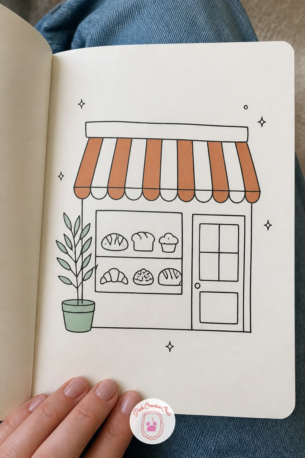Bakery With a Striped Awning — Shift from homes to a small shopfront with a bakery front window full of simple loaf and pastry shapes. House doodles