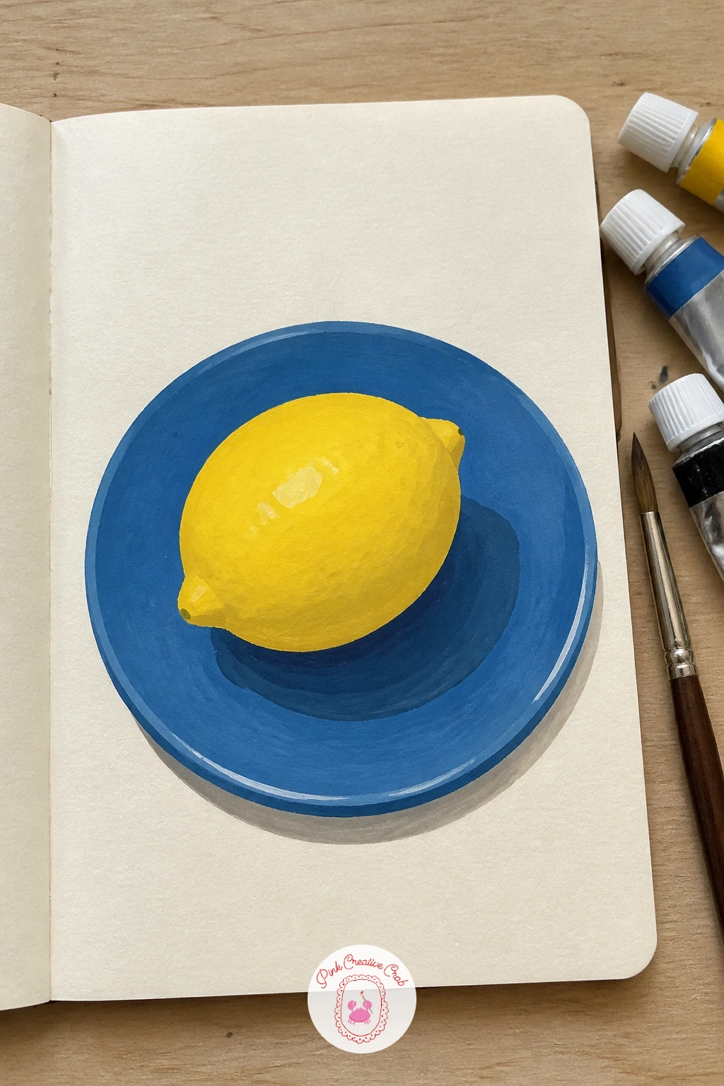 Lemon Study On A Blue Plate — After the landscape grid, slow down with one single object: a lemon study on a blue plate. Gouache sketchbook
