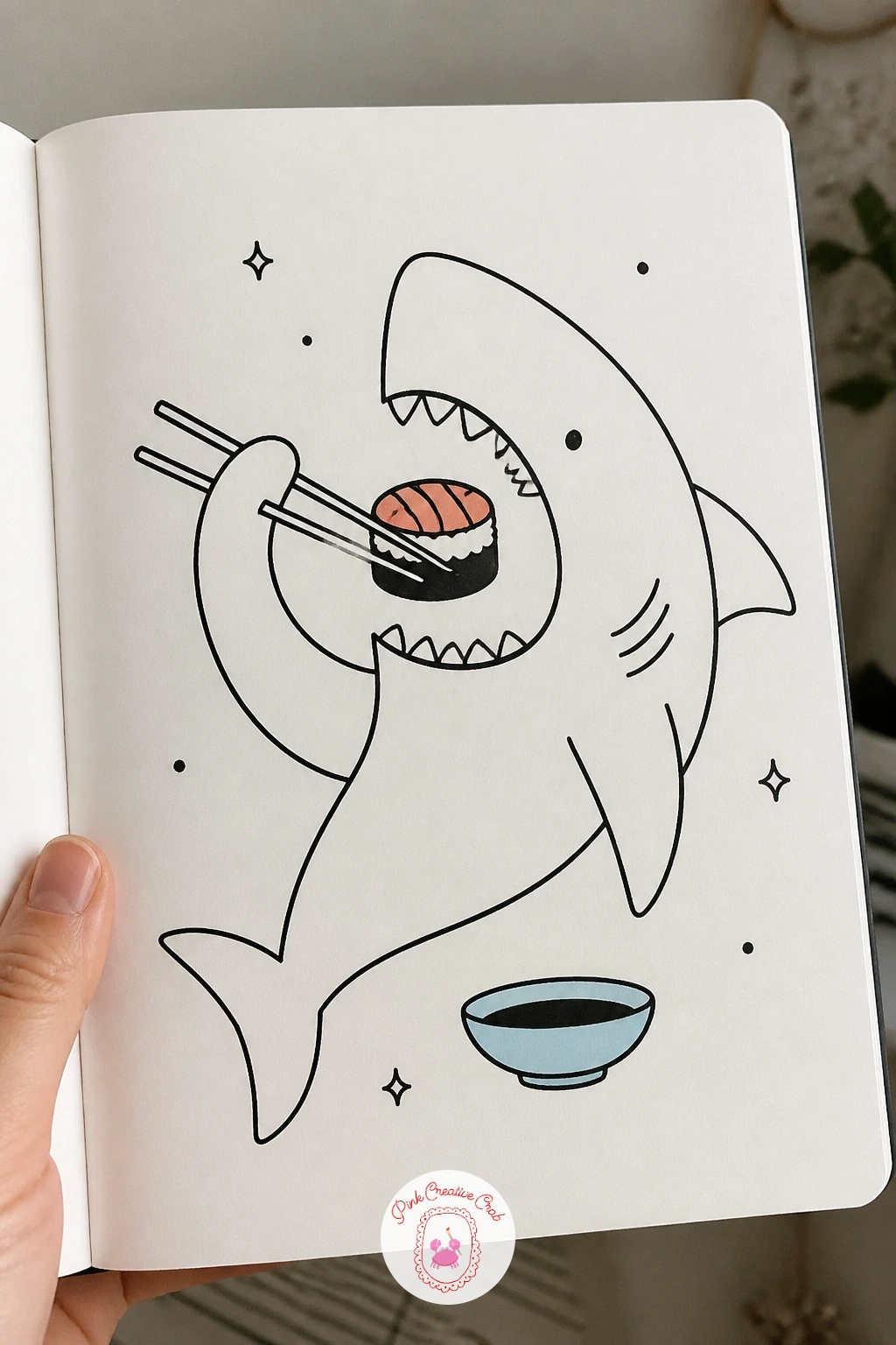Shark Eating Sushi — Close the list with a shark eating sushi, chopsticks held in one fin lifting a single piece toward an open mouth. Shark doodle