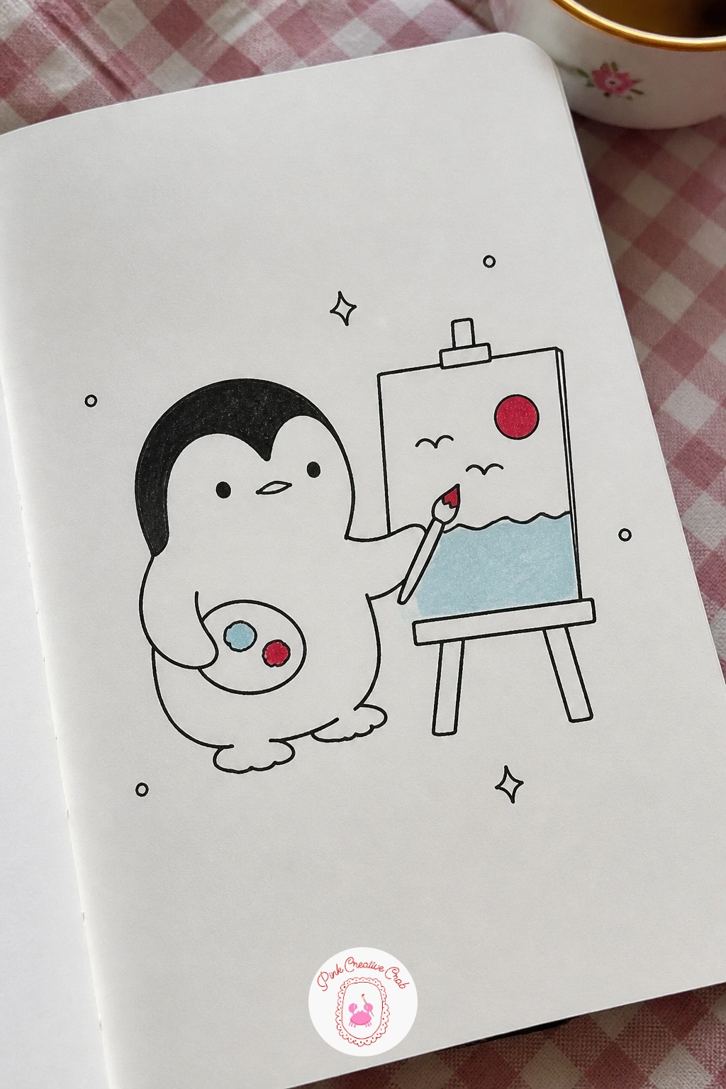 Penguin Painting At An Easel — Set up a tiny easel first, three thin legs and a small canvas propped on top, then stand the penguin in front of it holding a